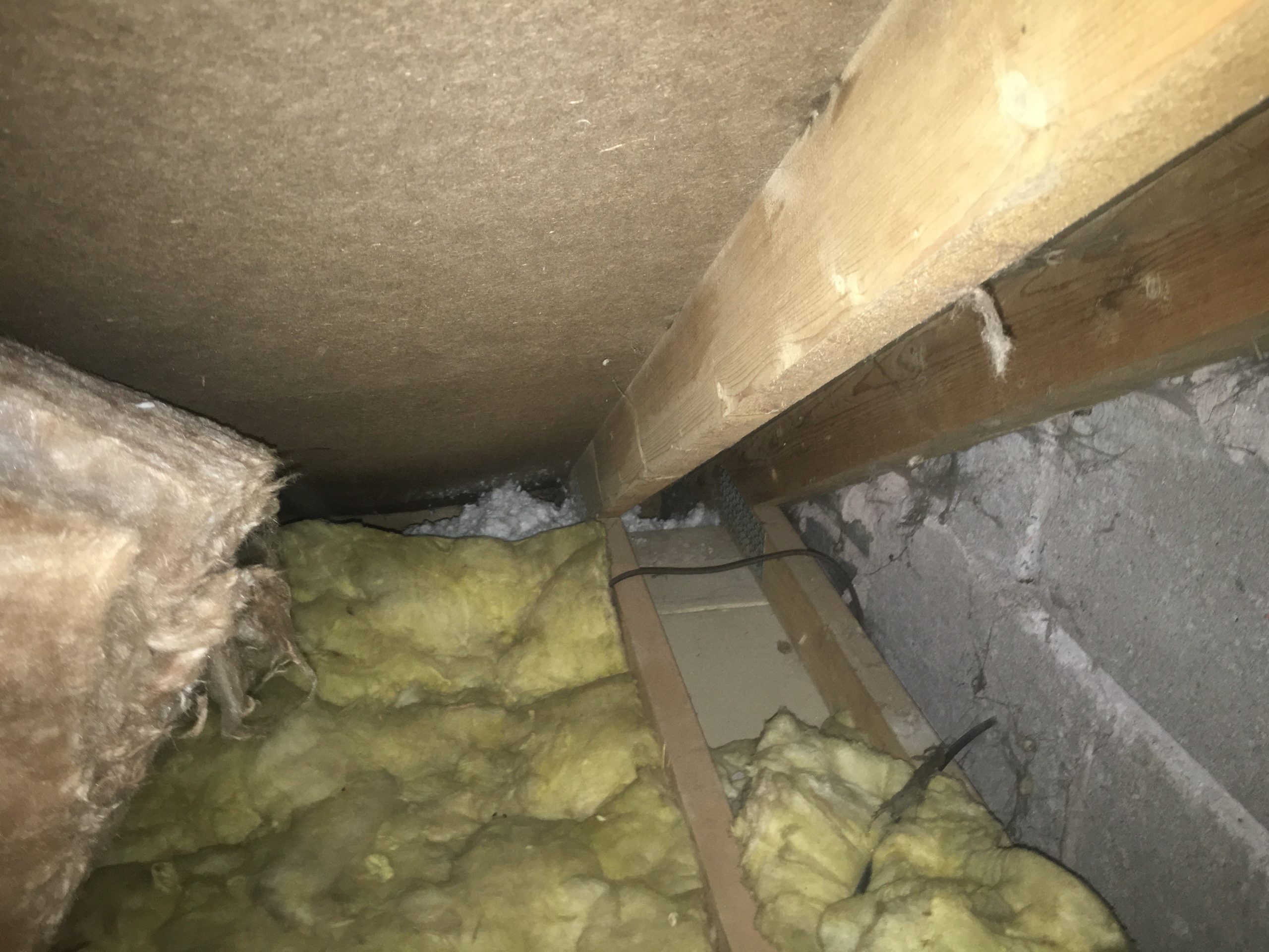Cavity wall insulation protruding from the top of the external walls, blocking air flow.